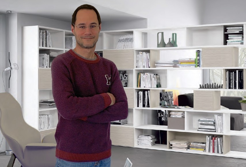 Jeune homme brun souriant dans un grand salon blanc